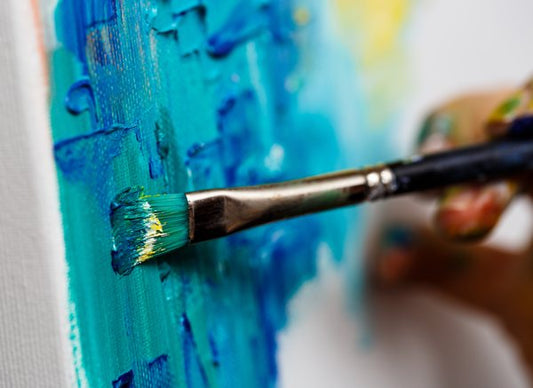 A canvas being painted on with paint imbued with mica powder.