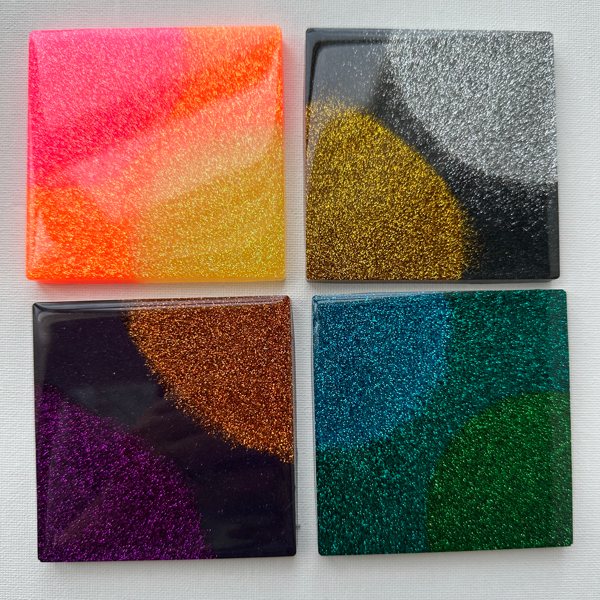 Four different epoxy resin coasters colored with various Pigmently Mica Powders.