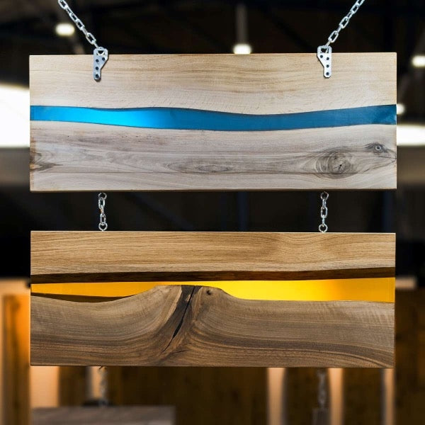 Two wooden resin trays with a tinted epoxy vein running through the length. One has a blue tint and the other has an orange tint.