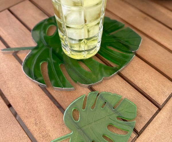 Two leaf-shaped green resin coasters, colored with the Grass Green, Neon Green, and Jade Green Epoxy Dyes by Pigmently