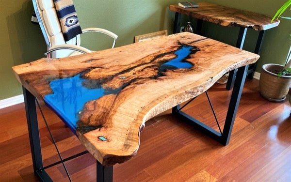 A wooden epoxy resin table with tinted resin reservoirs colored with blue mica powder pigments.