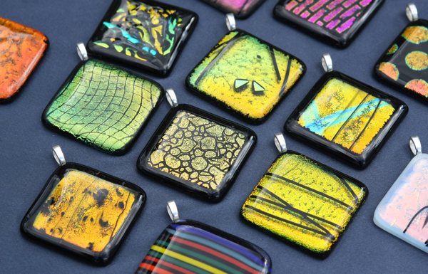 An array of various square keychains made using mica powder for art.
