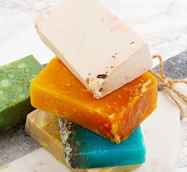 Several bars of soap, of different colors and ingredients, including mica powder.