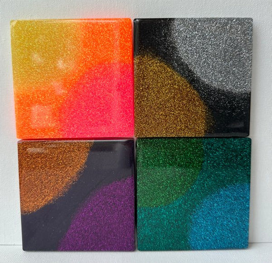 Four resin coasters colored with various mica powder pigments.