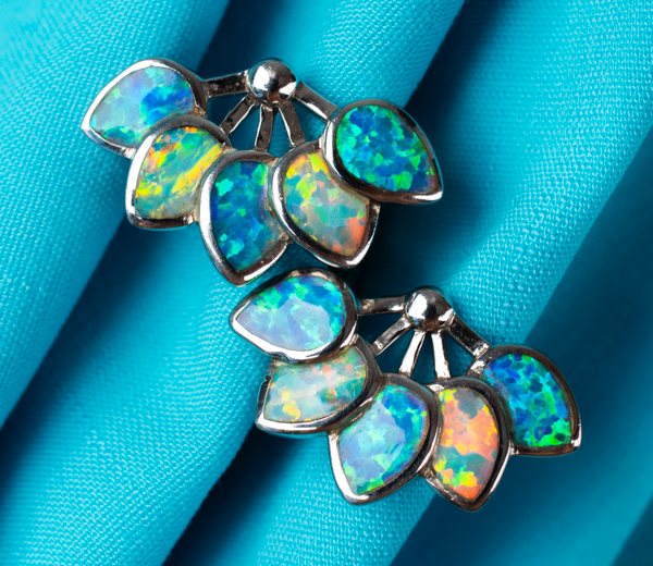 Colorful resin jewelry resting on light-blue fabric.