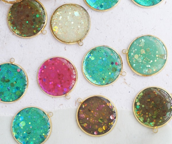A selection of resin keychains made in a circular shapes with various pigments.