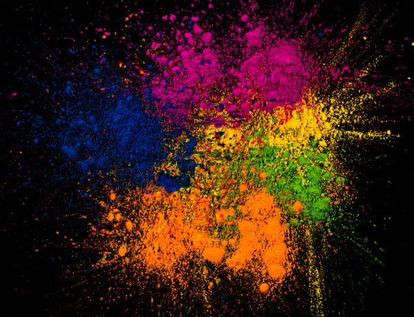 Several pigments of different colors spread out on a black surface.