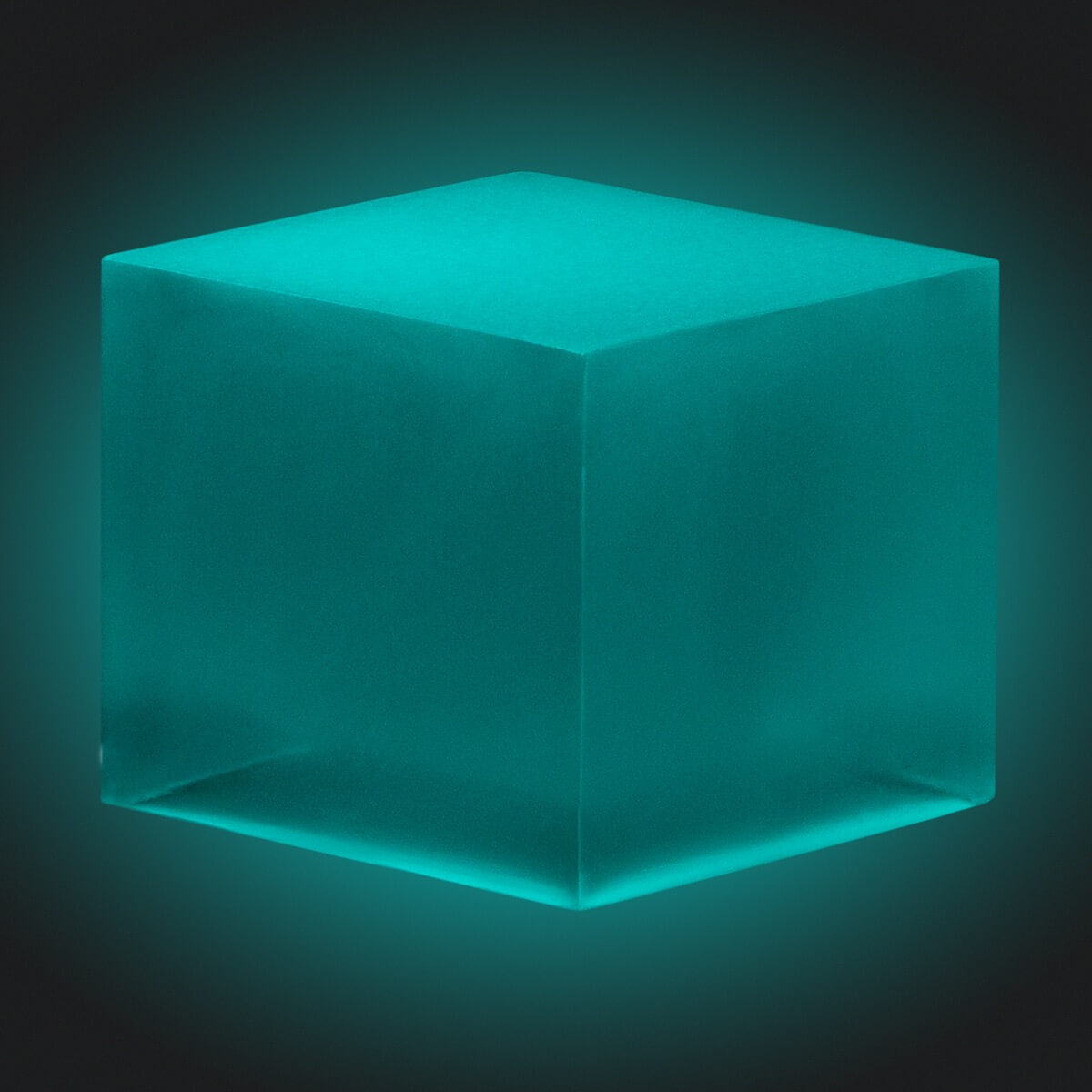 A resin cube made with the Blue Green Glow in the Dark Mica Powder Pigment by Pigmently, seen in a dark environment to showcase the glow effect.